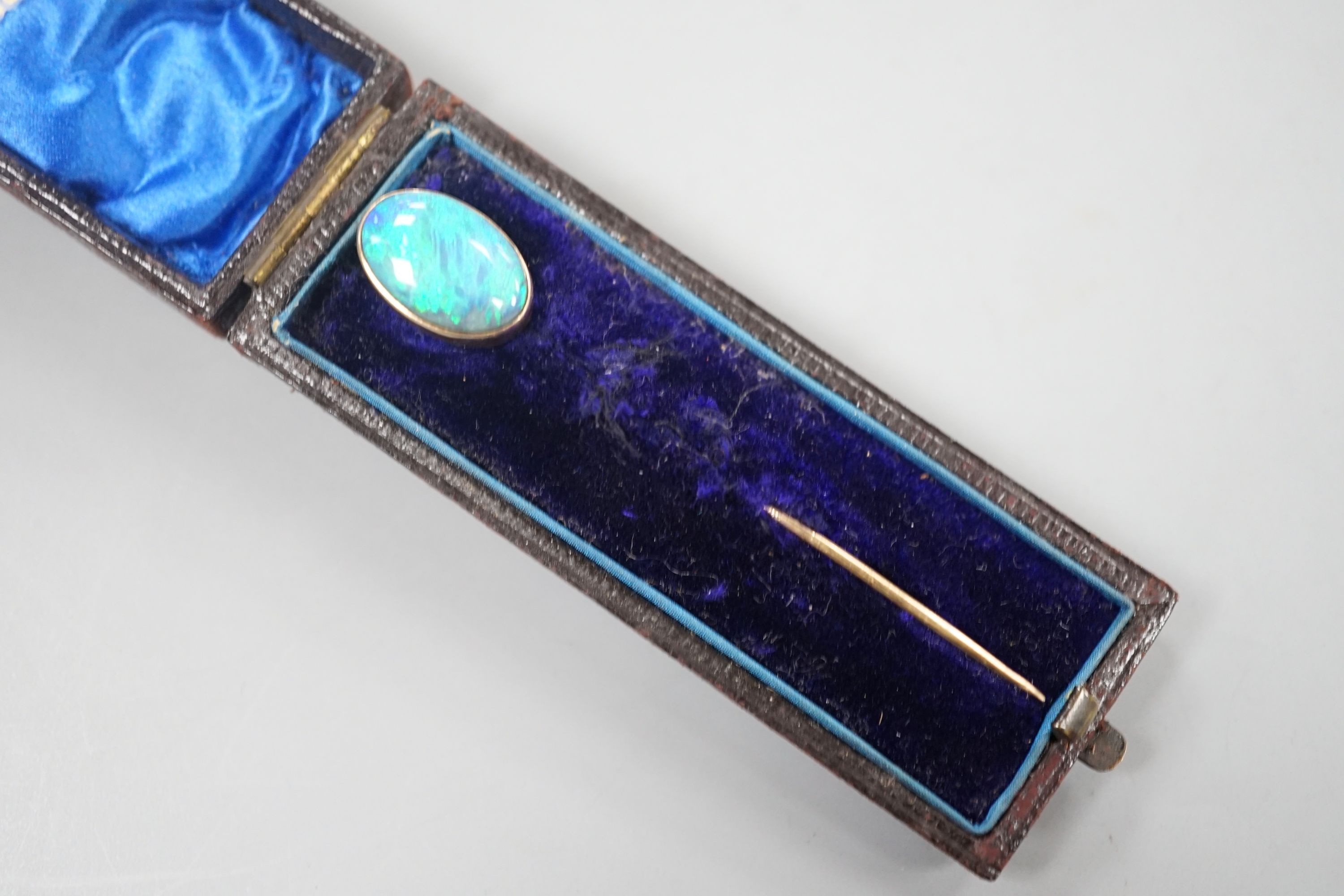 An Edwardian yellow metal and oval black opal set stick pin, 67mm, gross 2.7 grams